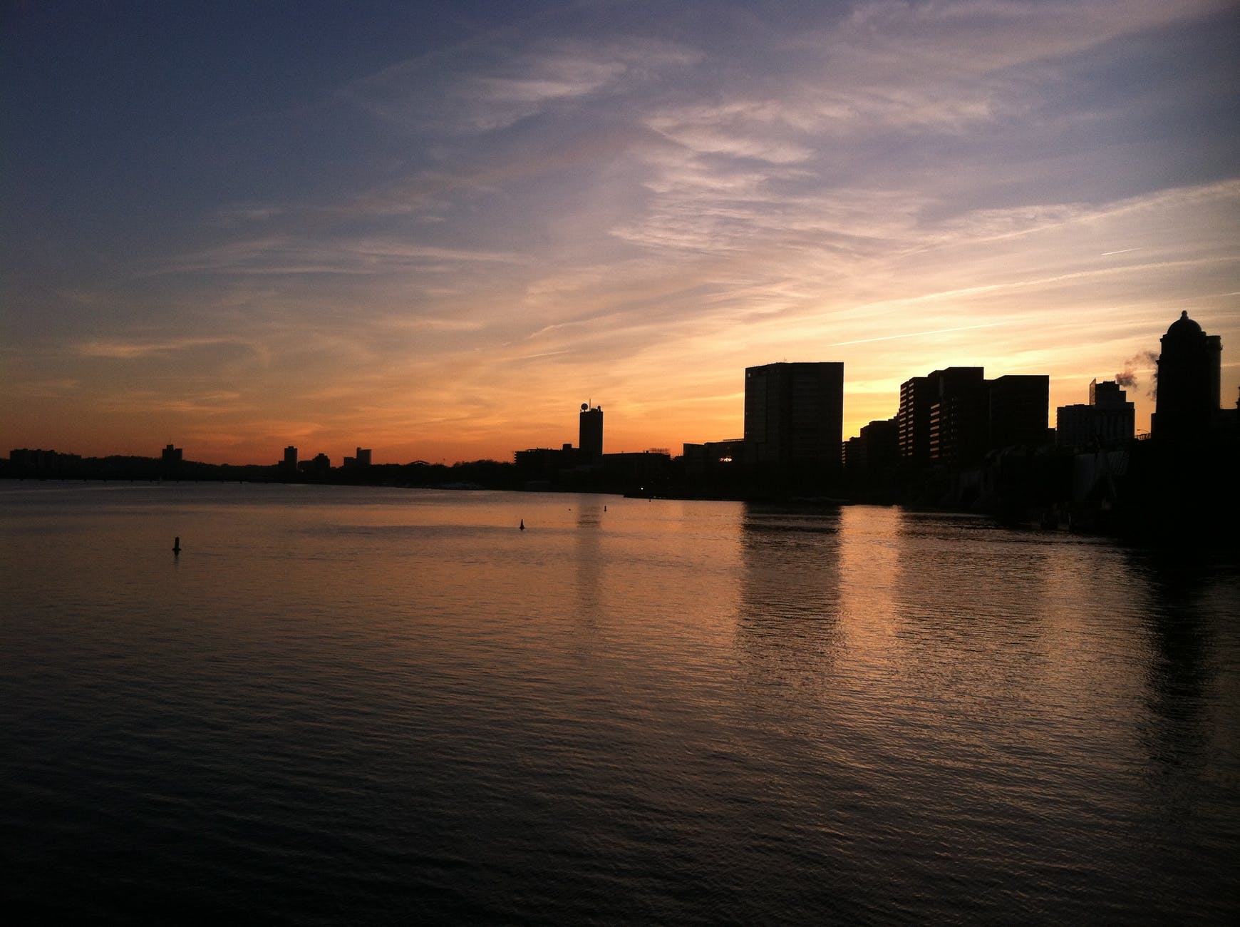 silhouette photograph of buildings near calm body of water