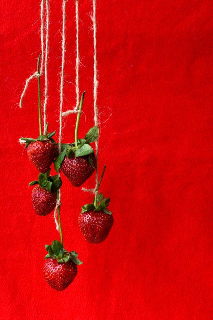 red strawberries on red textile