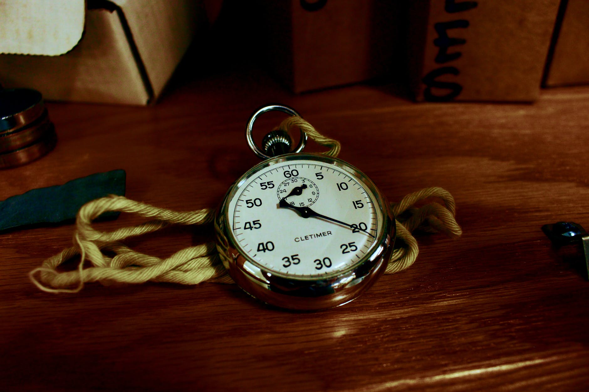 white pocket watch with gold colored frame on brown wooden board